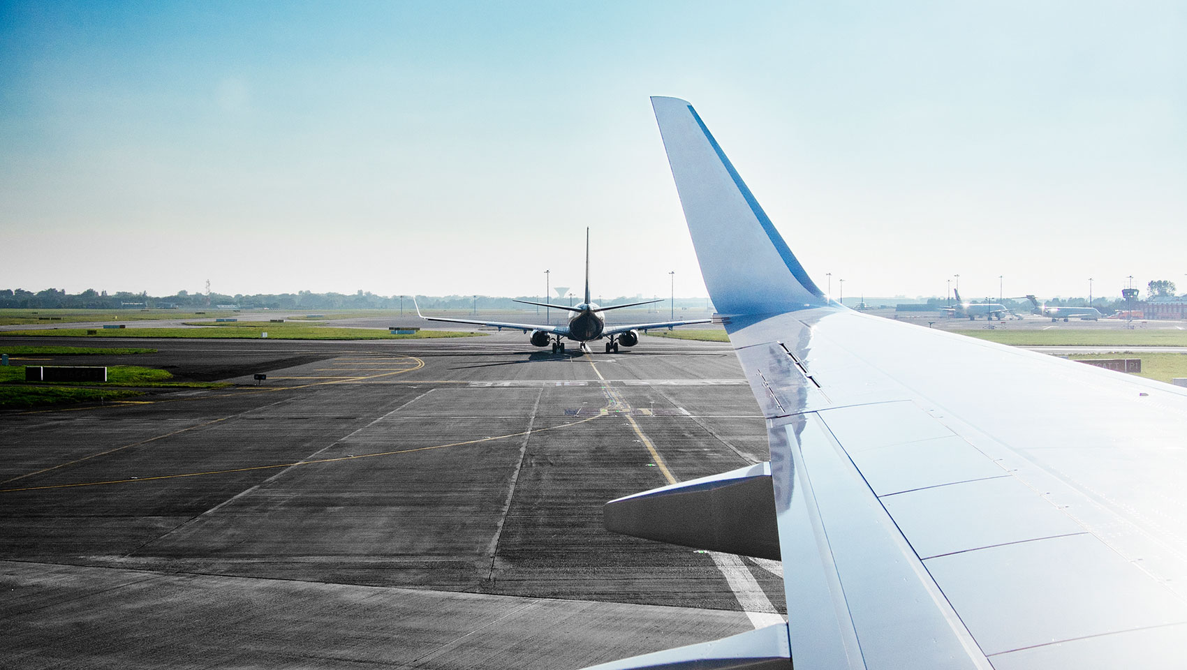 Airplane taking off from the view of another airplane window.