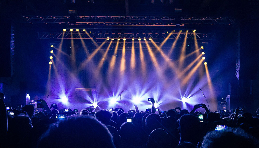 Concert Venue with people celebrating and a stage ahead of them