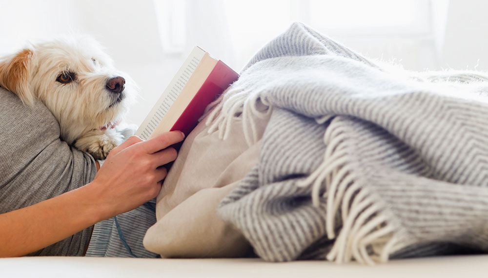 woman reading a book with her dog