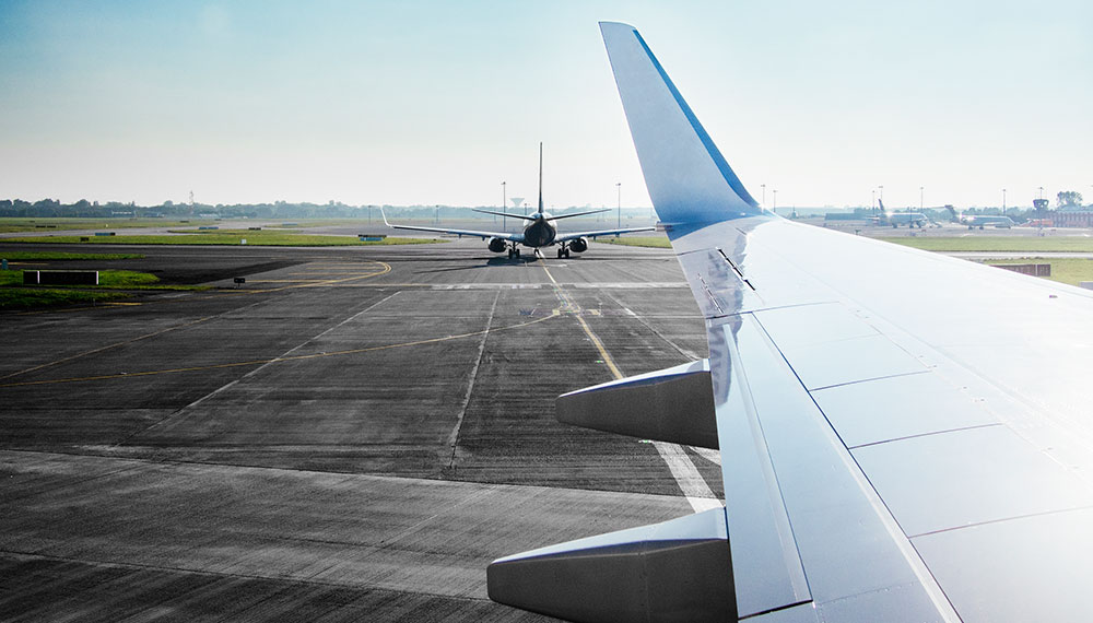 Airplane taking off from the view of another airplane window.