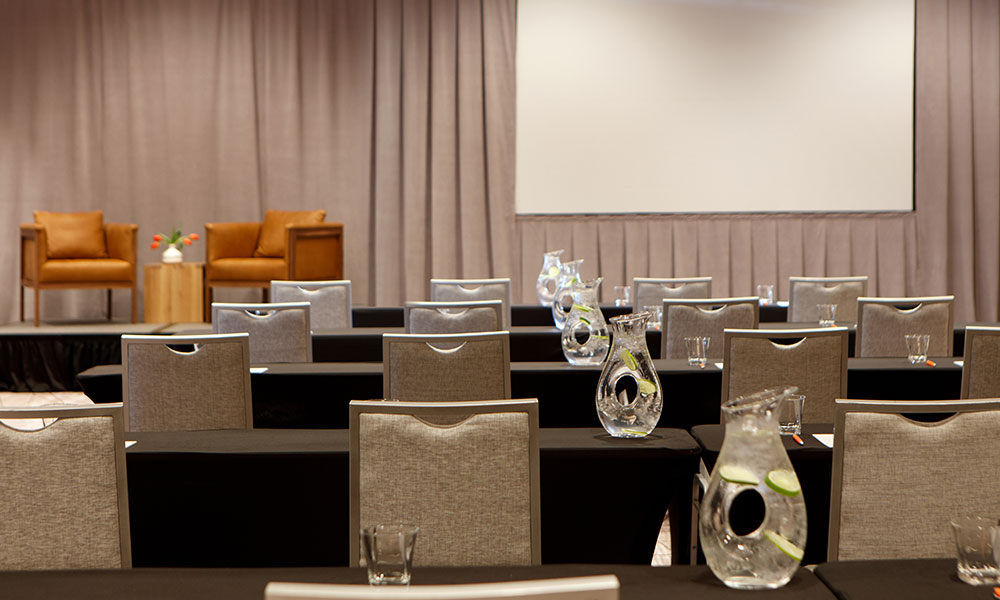 The Ballroom, light brown and gray undertones, set with round tables for a wedding