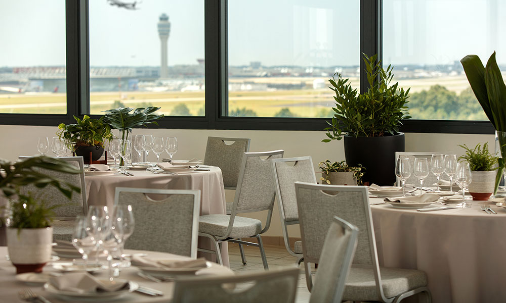 Outdoor rooftop lounge with plane taking off in the background